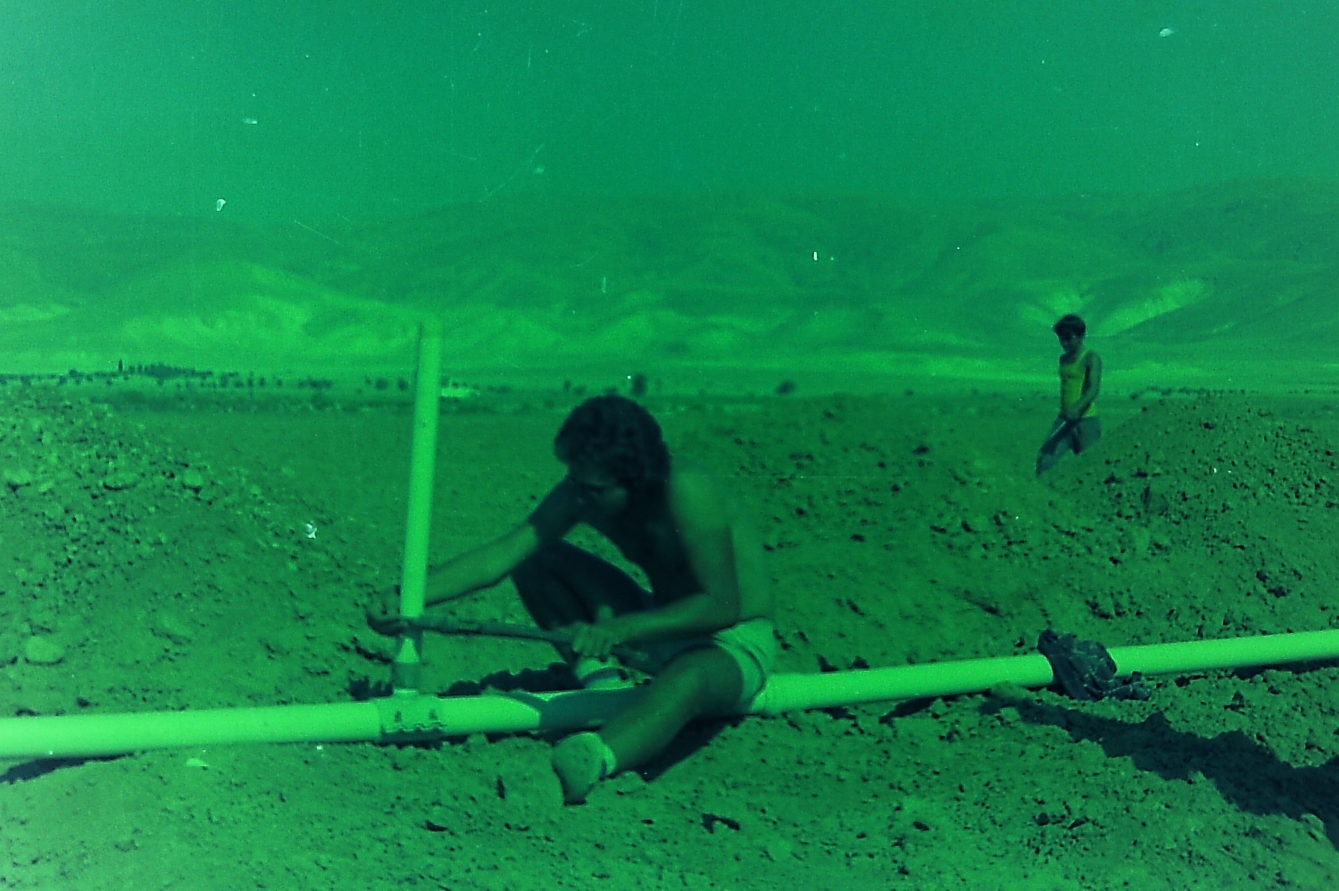 A teenage Saad laying irrigation pipe alongside his brother Samsam during the pipeline project.