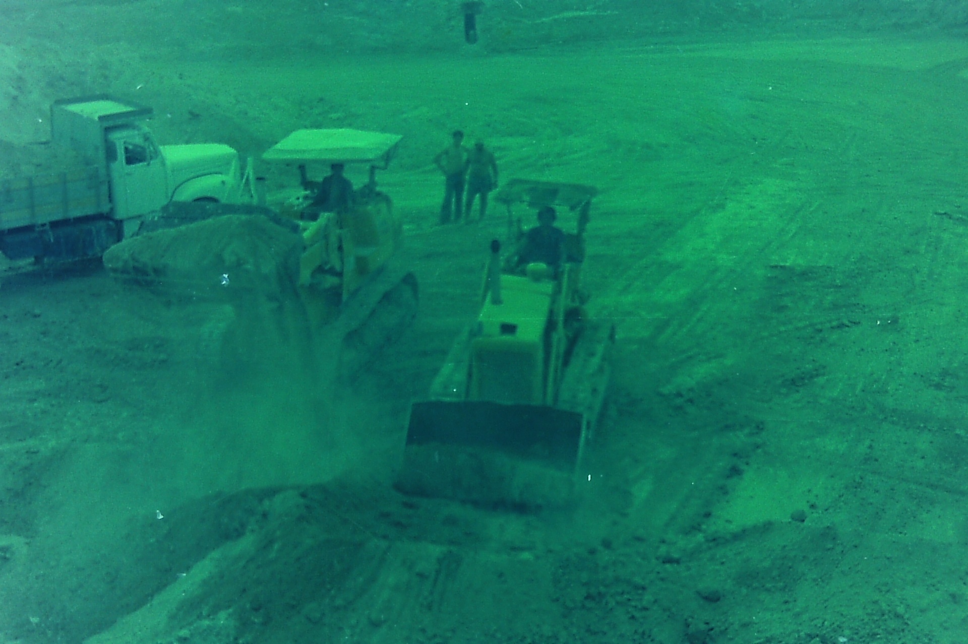 The dig in motion — eight meters of soil to move before the stones appeared.