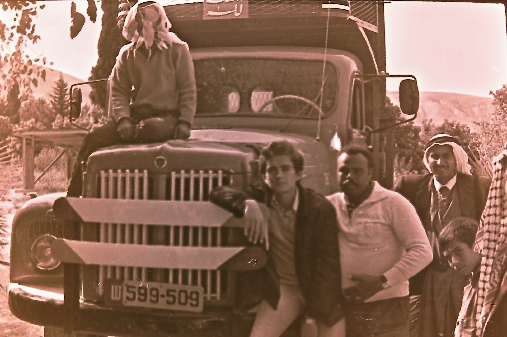 Teenage Saad Al-Nimer leaning on truck 599-509 with friends and family.