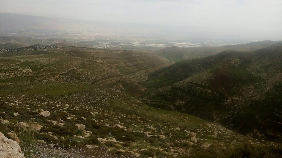 Looking down on Fasayel from the western hills — the valley opening below in spring.