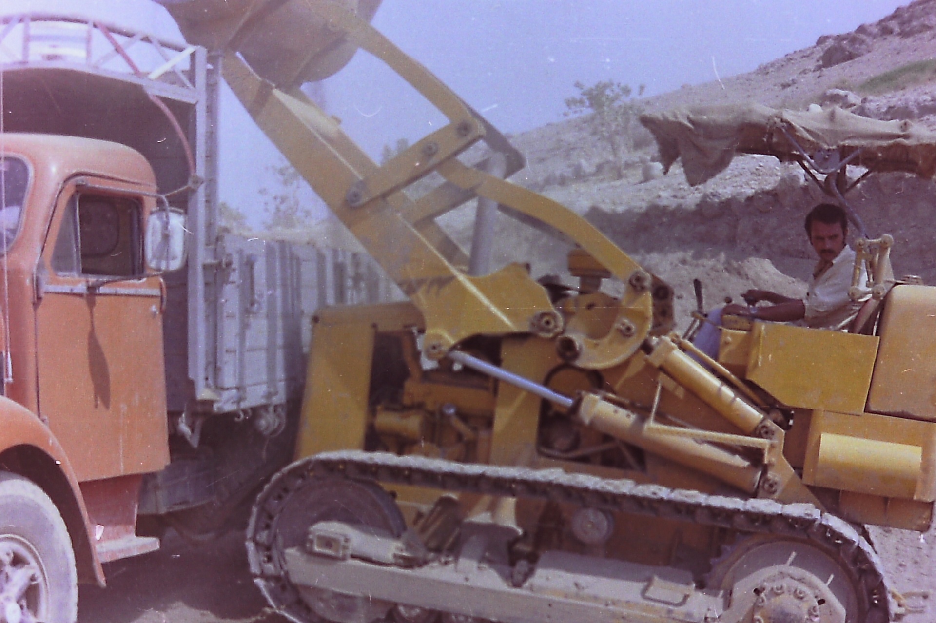 Samsam Al-Nimer on the yellow loader, working beside the red Scania at the Roman Pool excavation.